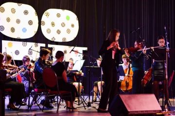 Smyčcový orchestr se sólistkou při koncertu
