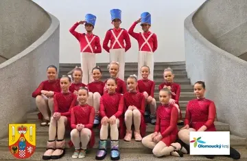 Tanečnice v červených kostýmech a vojáčci na schodech, soutěžní vystoupení v Olomouckém kraji