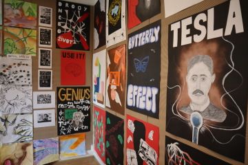 Výstava žákovských plakátů a kreseb na stěně, mezi nimi portrét Nikoly Tesly