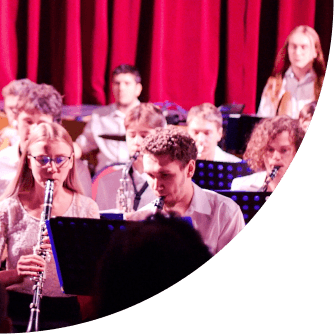 Žáci hrají na klarinety v orchestru