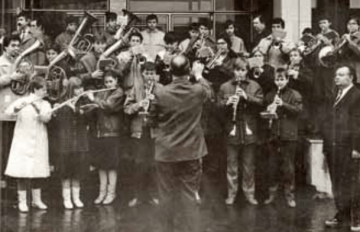 Archivní fotografie dechového orchestru žáků s dirigentem