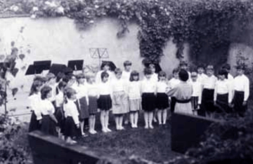 Archivní fotografie dětského pěveckého sboru při vystoupení venku